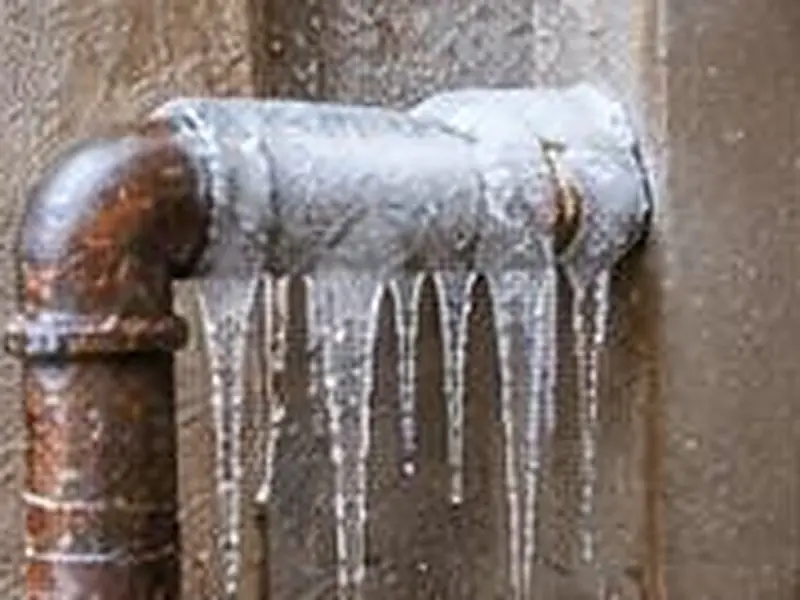 Frost and icicles on an old iron pipe