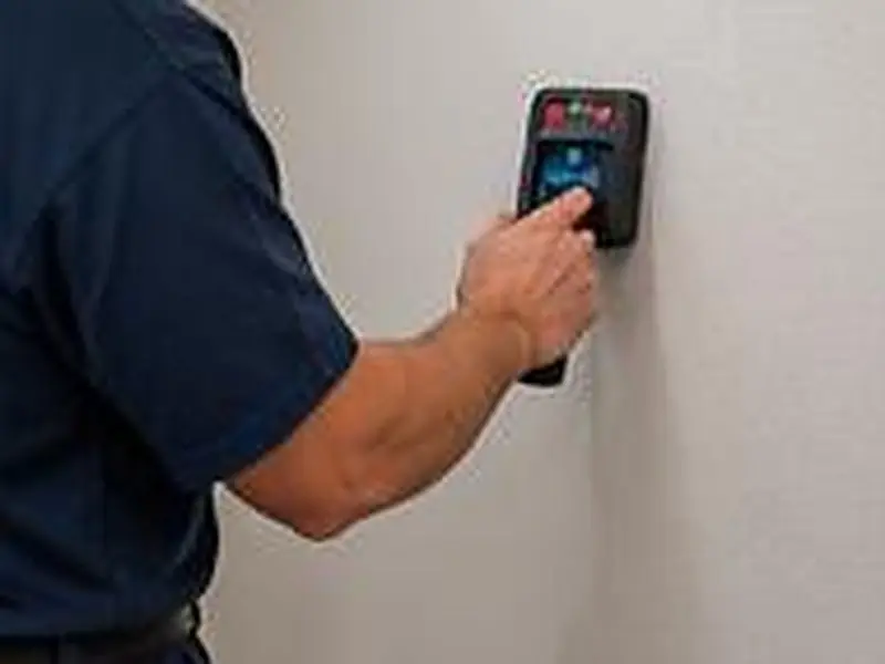 Technician checking a wall with a moisture meter